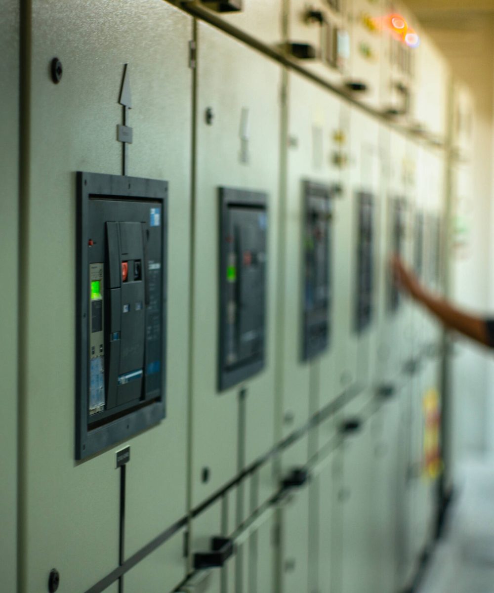 Blurred portrait of technician doing the preventive maintenance in the control room. Workers monitoring the status of electronic devices by check list.